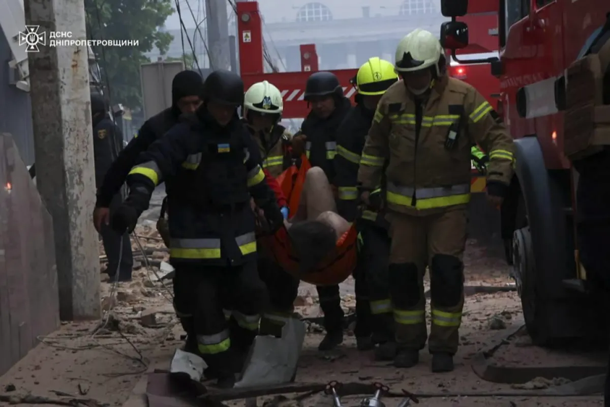 Salvatori ucraineni purtând o persoană rănită la locul unui atac cu rachetă asupra unei clădiri rezidențiale din orașul Dnipro, regiunea Dnipropetrovsk, sud-estul Ucrainei, 19 aprilie 2024, pe fondul invaziei ruse.