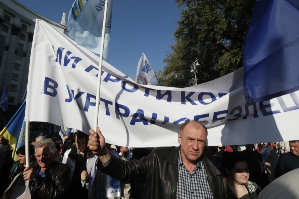 Oamenii poartă o pancartă cu „Suntem împotriva corupției” în timpul unui miting în fața clădirii guvernamentale din centrul orașului Kiev, Ucraina, 17 octombrie 2018.