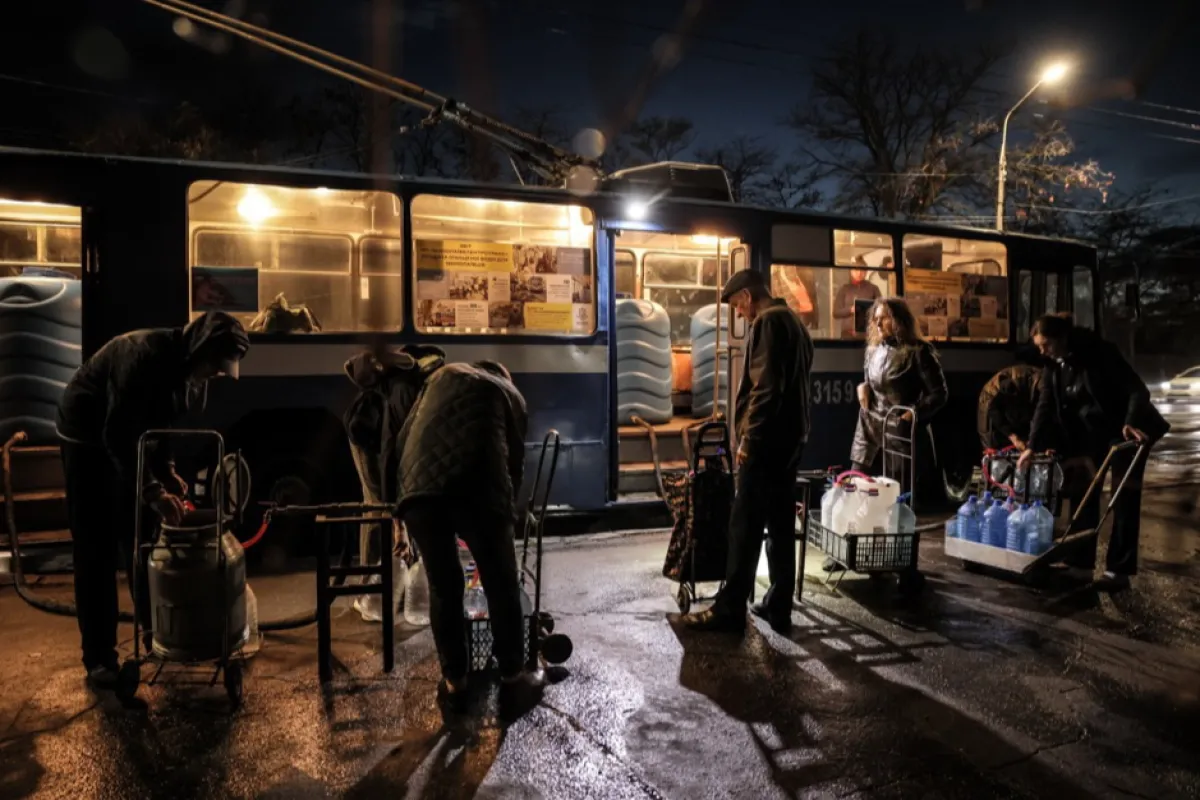 Localnicii stau la coadă pentru a primi apă de la un cărucior de alimentare, care furnizează apă curată în Nikolaev, Ucraina, 1 noiembrie 2023.