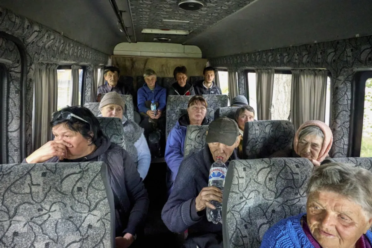 Ucrainenii stau într-un autobuz în timp ce sunt evacuați din teritoriile apropiate de granița cu Rusia în zona Harkov, Ucraina, 11 mai 2024, pe fondul invaziei ruse.