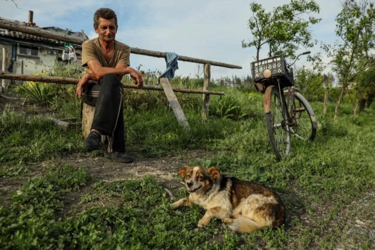 Mykola, 58 de ani, și câinele său Putin stau în fața casei din satul Bohorodychne, regiunea Donețk, Ucraina, 29 mai 2023 (emis la 19 iunie 2023).