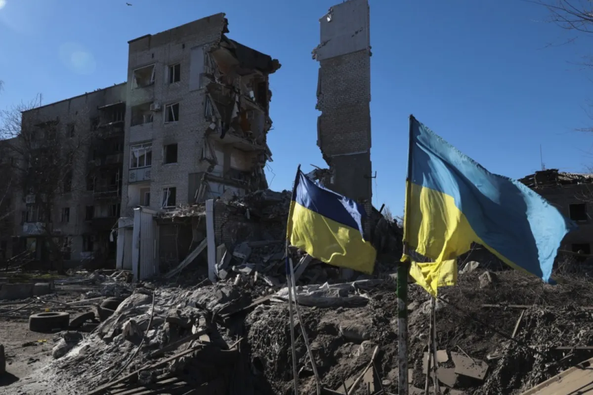 Steaguri ucrainene flutură în fața clădirilor rezidențiale avariate din Orikhiv, lângă linia frontului în regiunea Zaporojie, sud-estul Ucrainei, 28 februarie 2024.