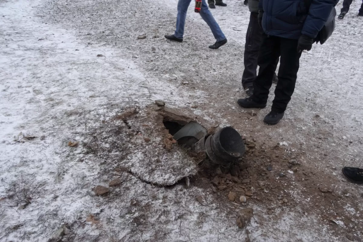 Cetăţenii locali stau lângă resturile unei rachete pe o stradă din oraşul Kramatorsk, din estul Ucrainei, 10 februarie 2015.