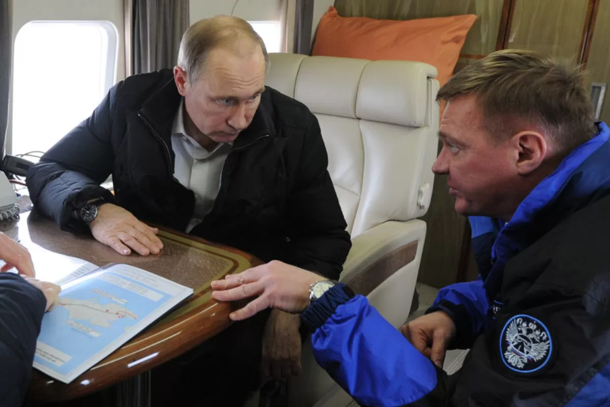 Președintele rus Vladimir Putin și șeful Agenției Federale de Autostrăzi Rosavtodor, Roman Starovoit, vorbesc în timp ce zboară peste peste strâmtoarea Kerci din Rusia, 18 martie 2016.