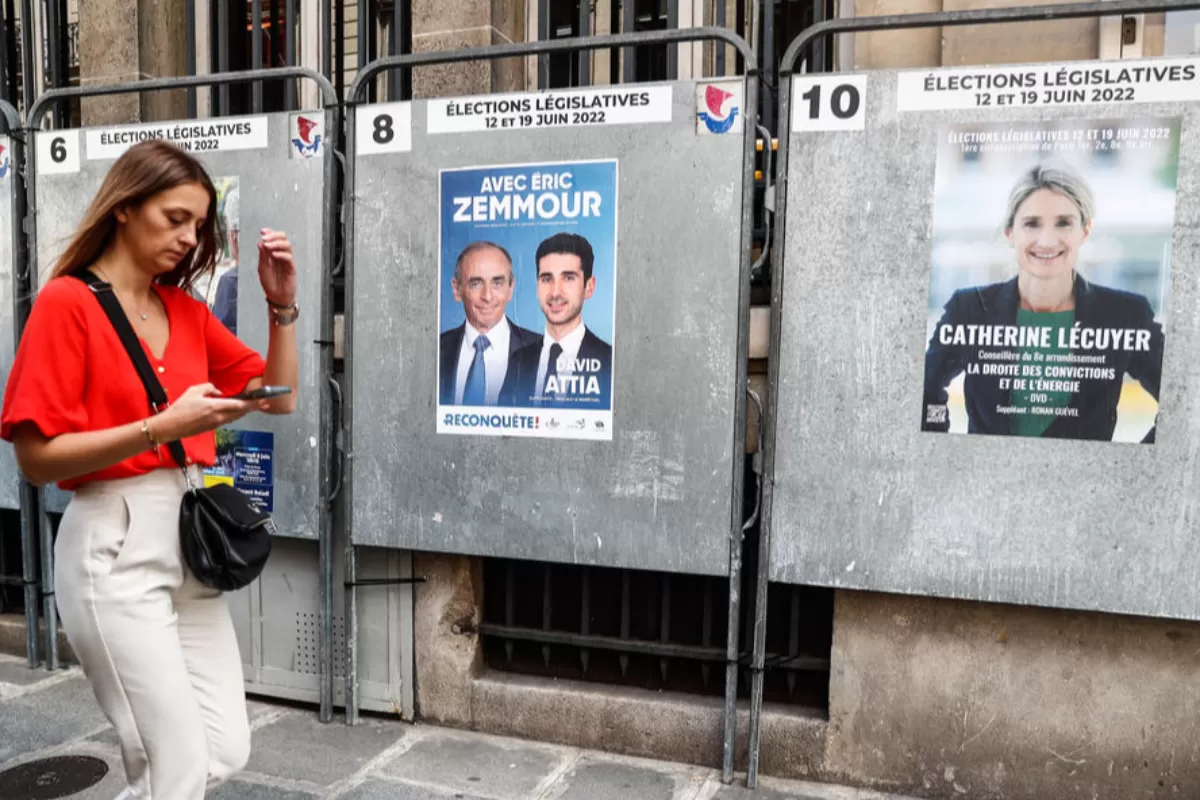 O femeie trece pe lângă afișe electorale la Paris, Franța, 10 iunie 2022.