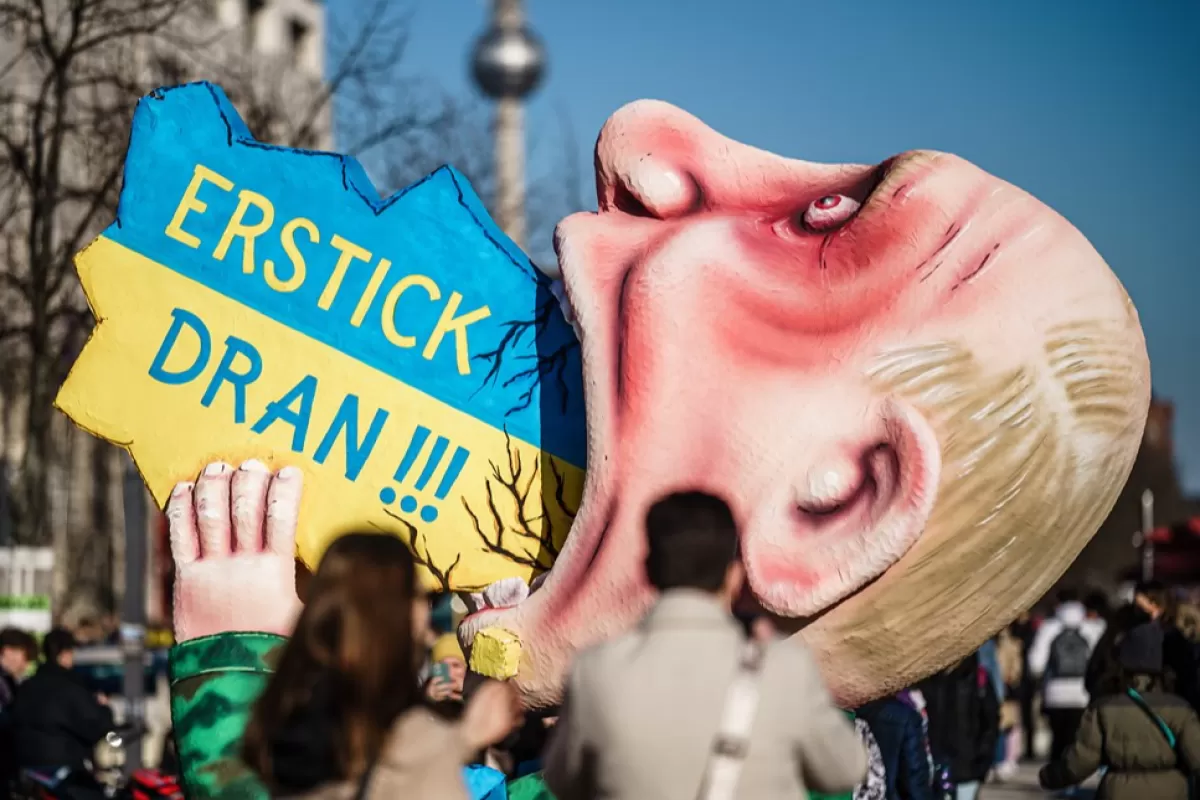 Să-ți stea în gât!!!' e sloganul unui balon de carnaval care îl arată pe președintele rus Putin în timp ce înghite un obiect în forma și culorile naționale ale Ucrainei, Berlin, Germania, 12 martie 2022.