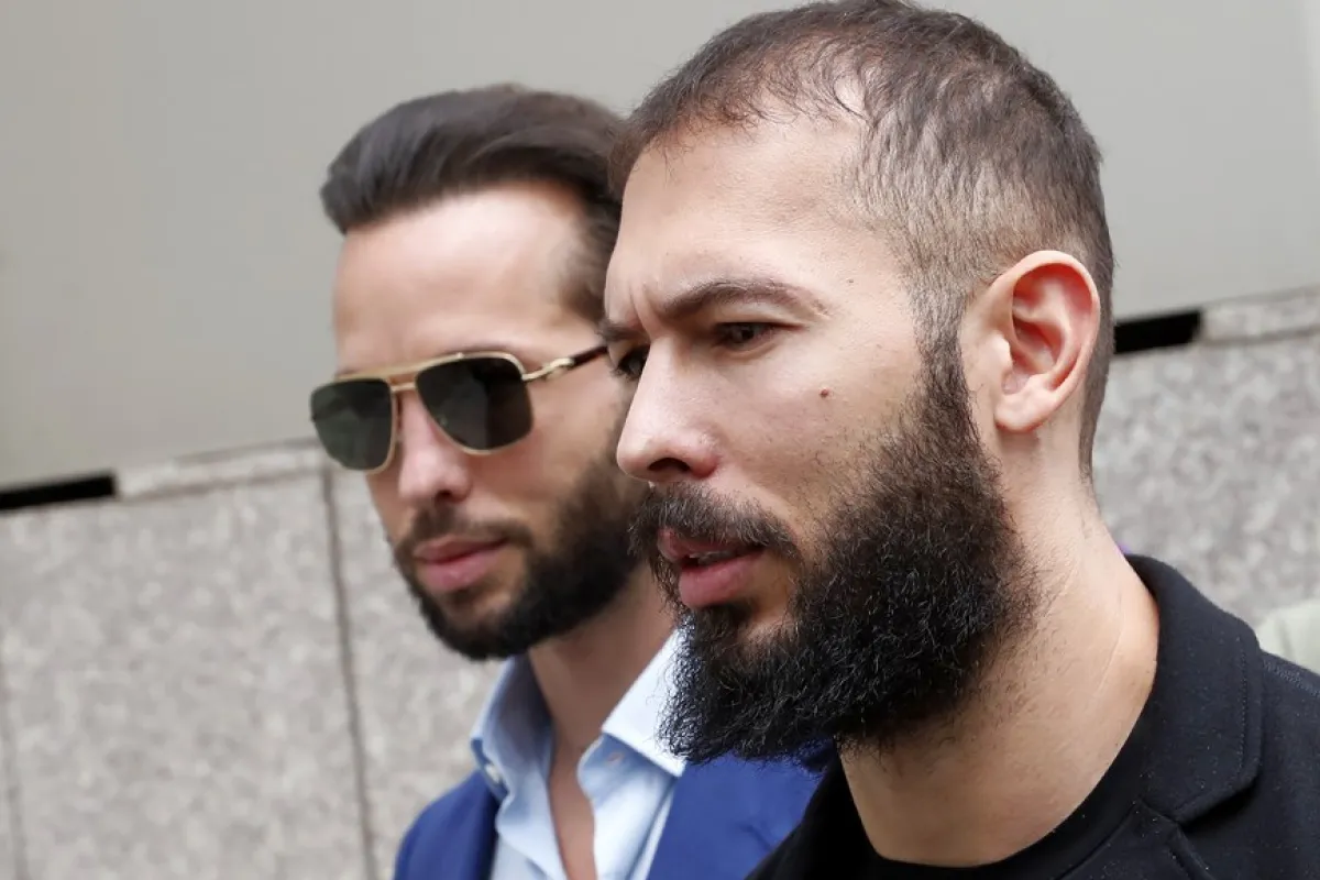 Fostul kickboxer profesionist și influencer al rețelelor de socializare Andrew Tate (R), este urmat de fratele său Tristan (L), în timp ce părăsește instanța după ce a fost prezentat unui judecător pentru prelungirea arestului la domiciliu, în București, România, 21 aprilie 2023. Andrew Tate și fratele său Tristan au fost arestați la 29 decembrie 2022 ca urmare a anchetei DIICOT sub acuzația de trafic de persoane și intenția de a forma un grup de crimă organizată. Poliția română a declarat că cei doi frați și asociații lor au constrâns victimele pentru crearea unui serviciu de pornografie plătită pentru platformele de socializare. La 31 martie 2023, frații Tate și asociații lor au fost mutați din custodia poliției în arest la domiciliu cu efect imediat.