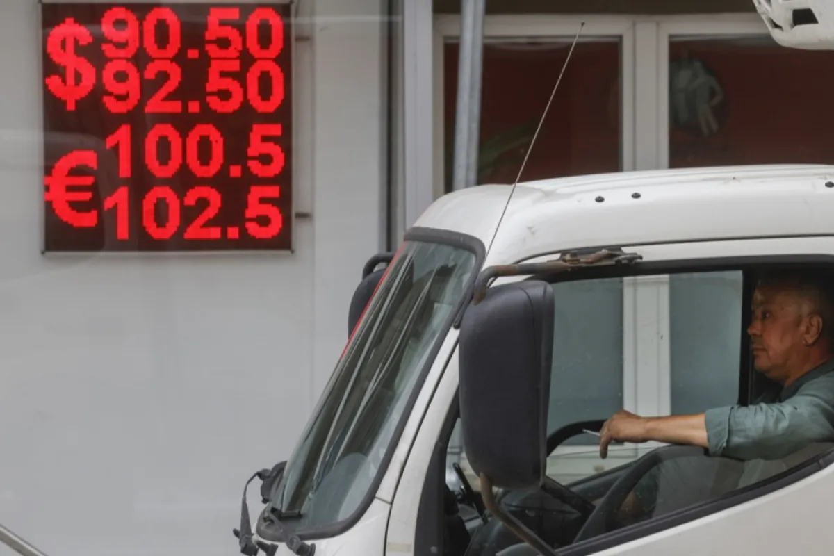 Un bărbat trece pe lângă un panou electronic care afișează cursurile de schimb ale dolarului american și euro față de rubla rusă la Moscova, Rusia, 09 august 2023.