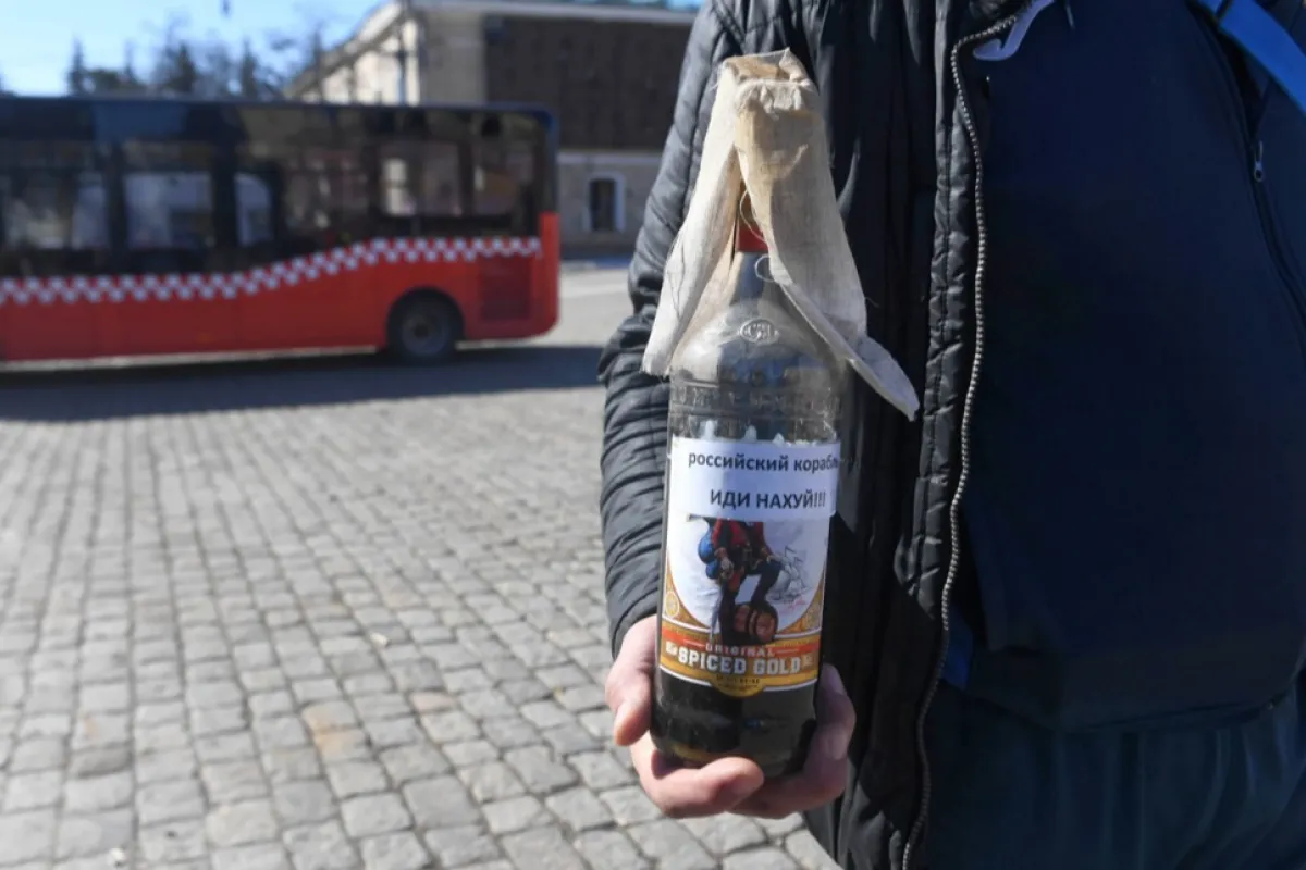 Un bărbat ține un cocktail Molotov în Piața Libertății din Harkov, Ucraina, 22 martie 2022.