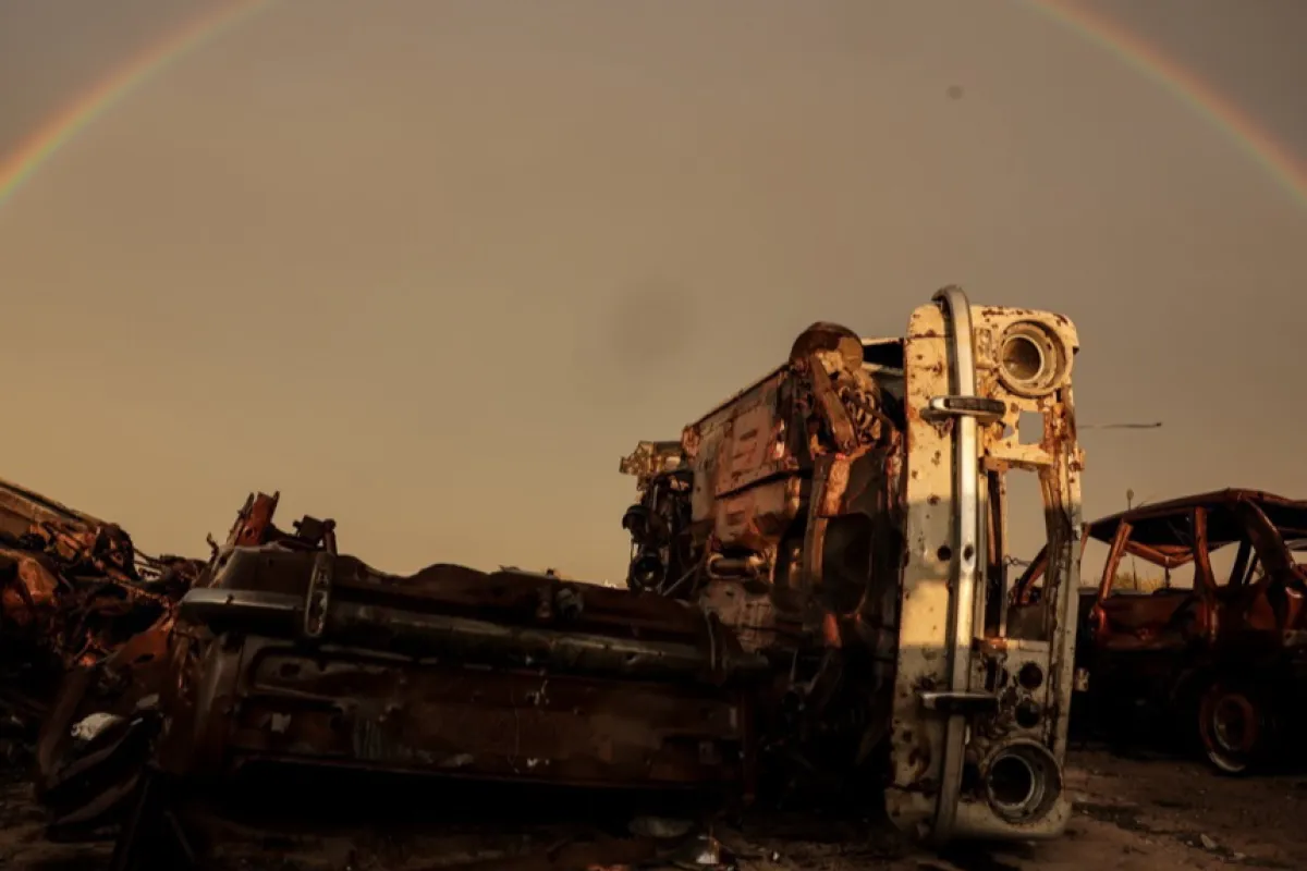 Un curcubeu deasupra vehiculelor distruse în satul Posad-Pokrovske din regiunea Herson, 1 noiembrie 2023. Rusia a bombardat 118 orașe și sate ucrainene în 24 de ore, mai mult decât în oricare altă zi din acest an, a anunțat ministrul de interne ucrainean, Ihor Klimenko, pe 02 noiembrie 2023.