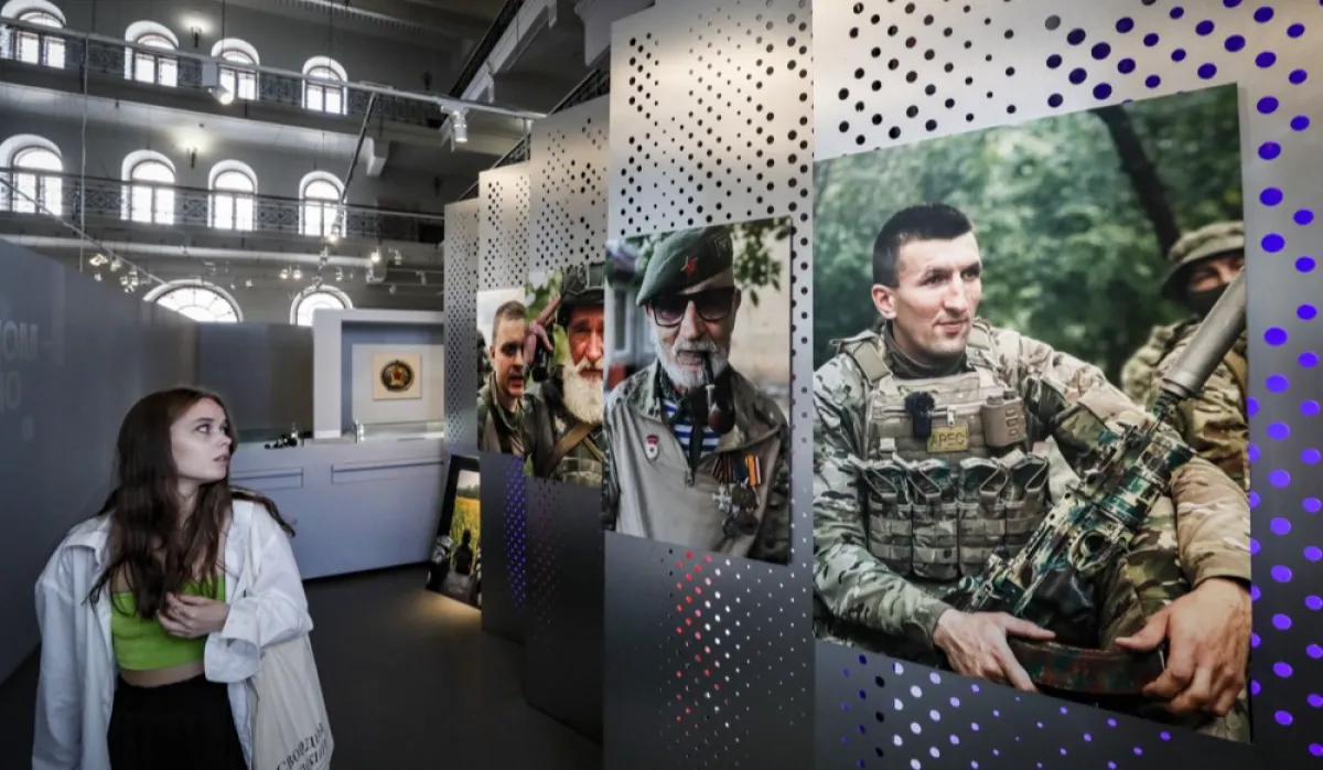 O vizitatoare trece pe lângă fotografii cu soldați la expoziția „Novorossiya”, Muzeul de Istorie de Stat din Moscova din Piața Roșie din Moscova, 5 septembrie 2023.