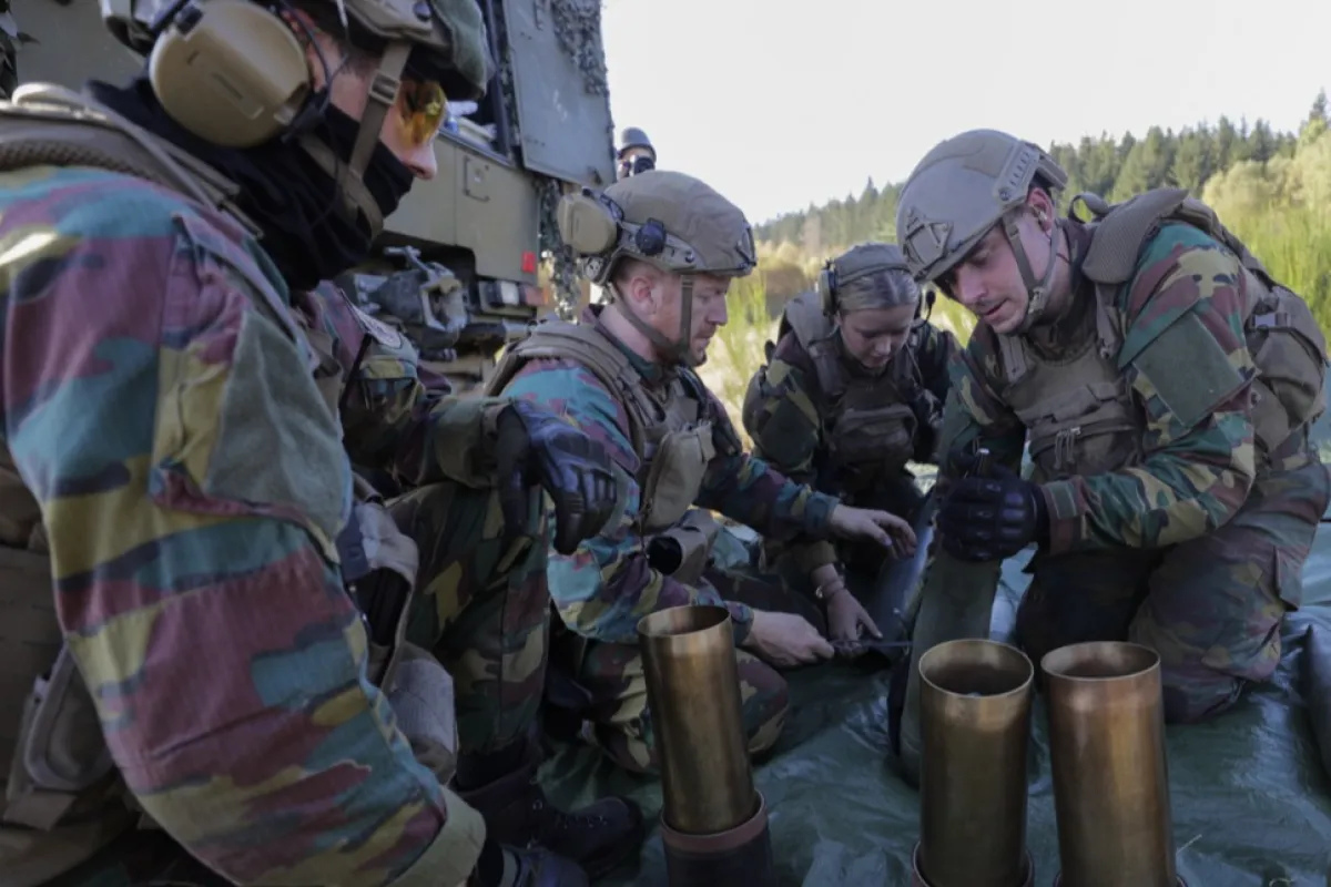 Soldații pregătesc un obuz pentru a fi tras de un obuzier GIAT LG1 de 105 mm, în timpul unui antrenament al Forței operative comune 23 de pregătire foarte ridicată a NATO, care are loc la terenul de antrenament Elsenborn Camp din Butgenbach, Belgia, 18 octombrie 2022.