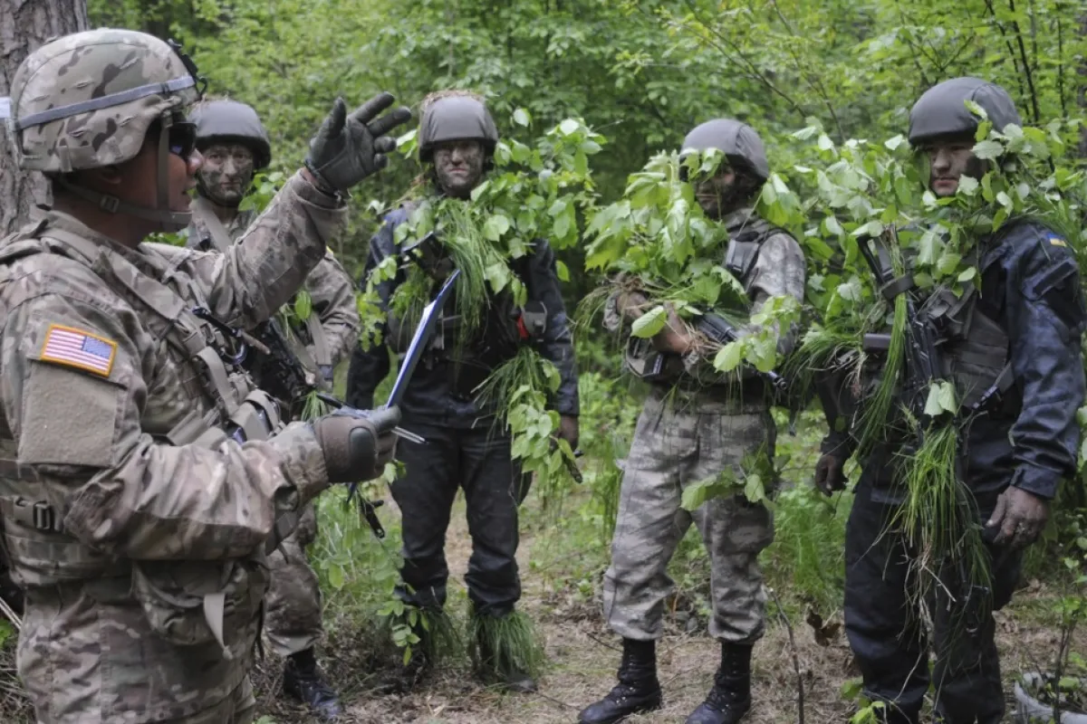 Un soldat american vorbește cu militari ucraineni în timpul unor exerciții militare comune în apropierea orașului Lviv, Ucraina, în vestul Ucrainei, 14 mai 2015.