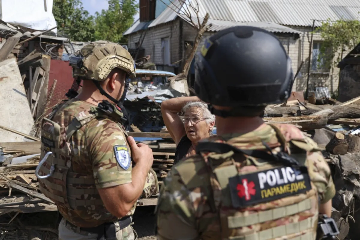 O femeie din Avdiivka le spune polițiștilor despre cum casa ei a fost recent, regiunea Donețk, Ucraina, 28 august 2023.