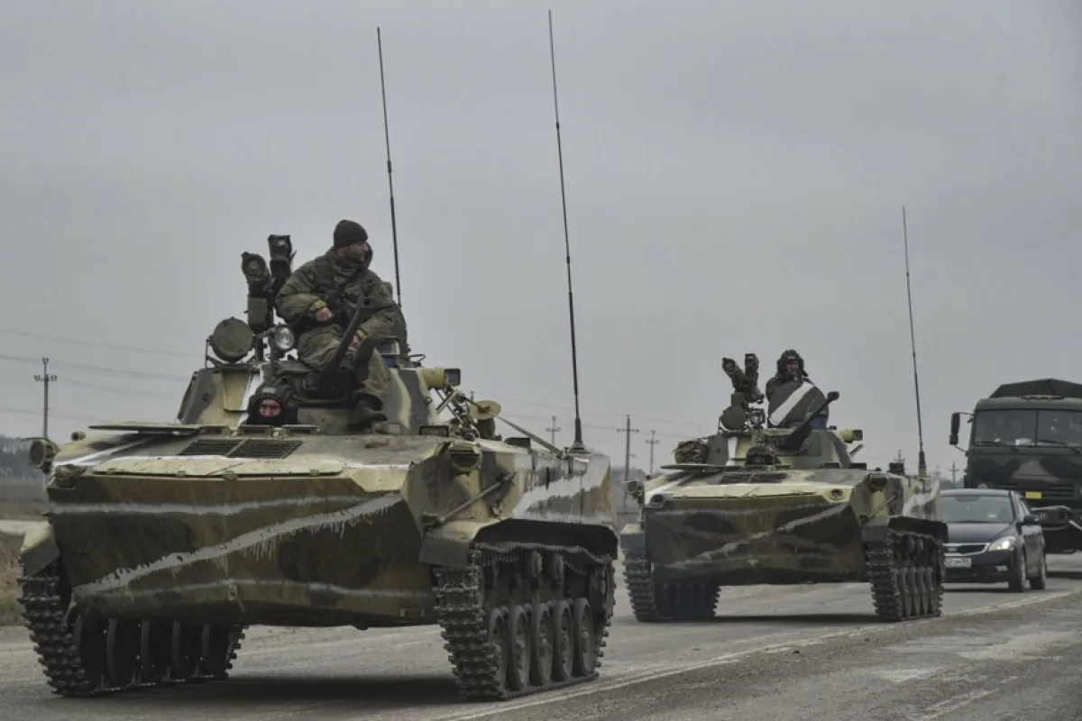 Soldații ruși de pe vehiculul amfibie de luptă de infanterie BMP-2 se îndreaptă spre Ucraina continentală pe drumul de lângă Armiansk, Crimeea, 25 februarie 2022. Trupele ruse au intrat în Ucraina pe 24 februarie, determinând președintele țării să declare legea marțială.