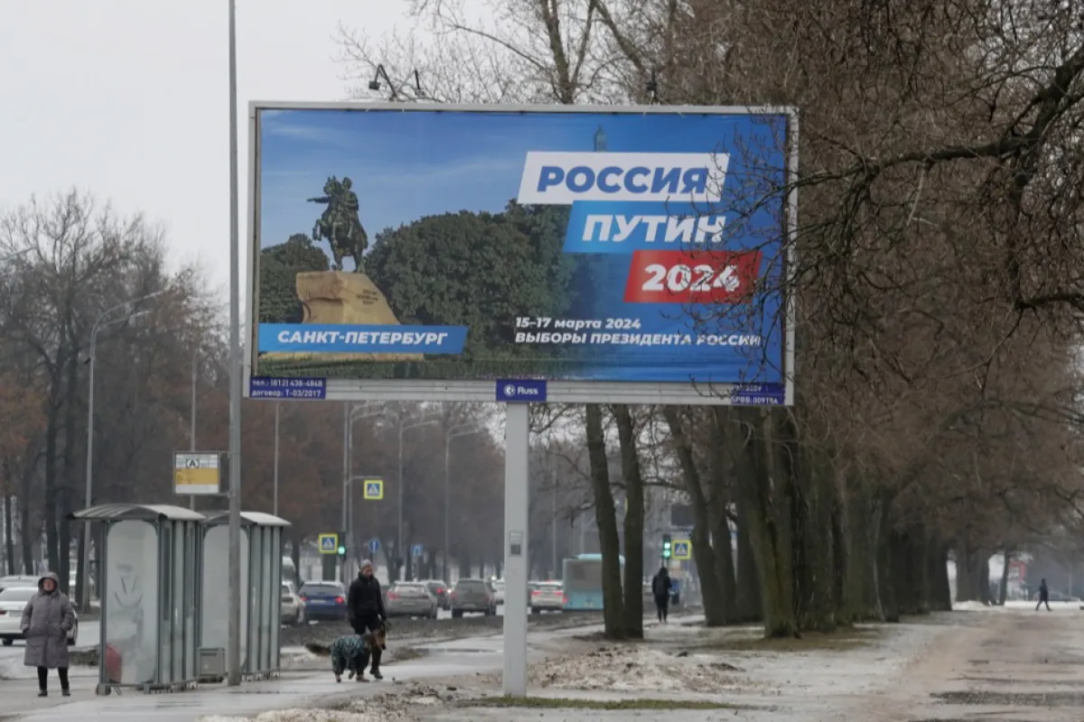 Oamenii trec pe lângă un panou care anunță alegerile prezidențiale din 2024 în Sankt Petersburg, Rusia, 27 februarie 2024.