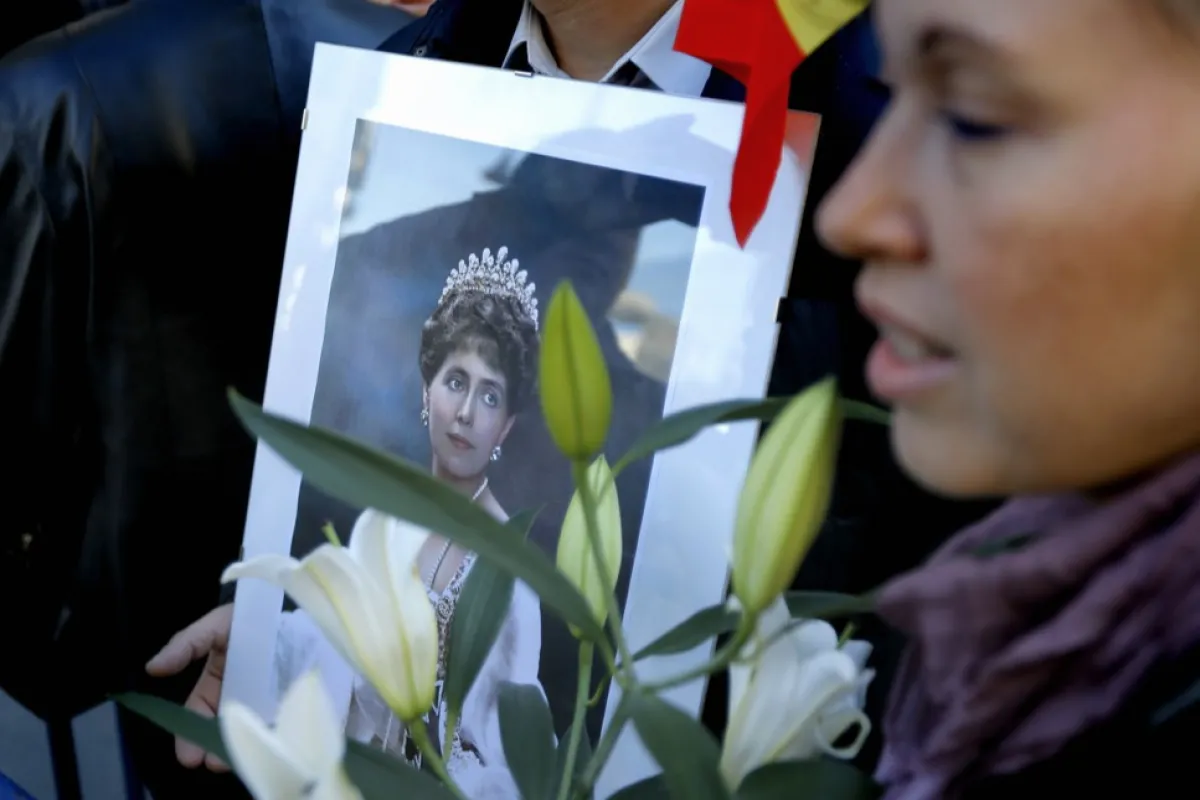 Portretul Reginei Maria a României este purtat de un susținător al regalității în timpul unei procesiuni în care Muzeul Național de Istorie predă familiei regale cutia de argint care conține inima Reginei Maria a României pentru a ajunge la locul său de odihnă final, castelul Peleș. unde a murit, situat la 140 km nord de București, România, 03 noiembrie 2015.