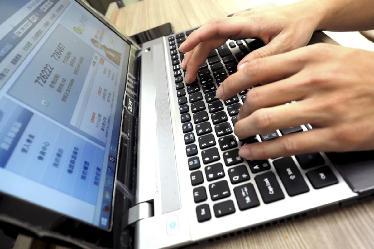 Un bărbat scrie pe tastatura unui laptop în Taipei, Taiwan, la începutul zilei de 4 februarie 2017.