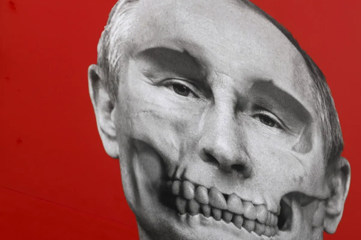 Un prim plan al afișului stilizat cu „capul de mort” al președintelui rus Vladimir Putin, văzut pe fațada Muzeului de Istorie Medicală din fața clădirii ambasadei ruse, în timp ce rușii din Letonia stau la coadă în ultima zi de vot la alegerile prezidențiale din Rusia la aceeași ambasadă din Riga, Letonia, 17 martie 2024.