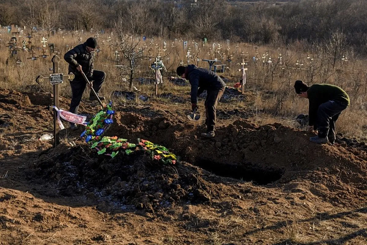 Lucrătorii serviciilor funerare au pus sicriul Galynei în mormânt în Chasiv Yar, regiunea Donețk, estul Ucrainei, 25 ianuarie 2023.